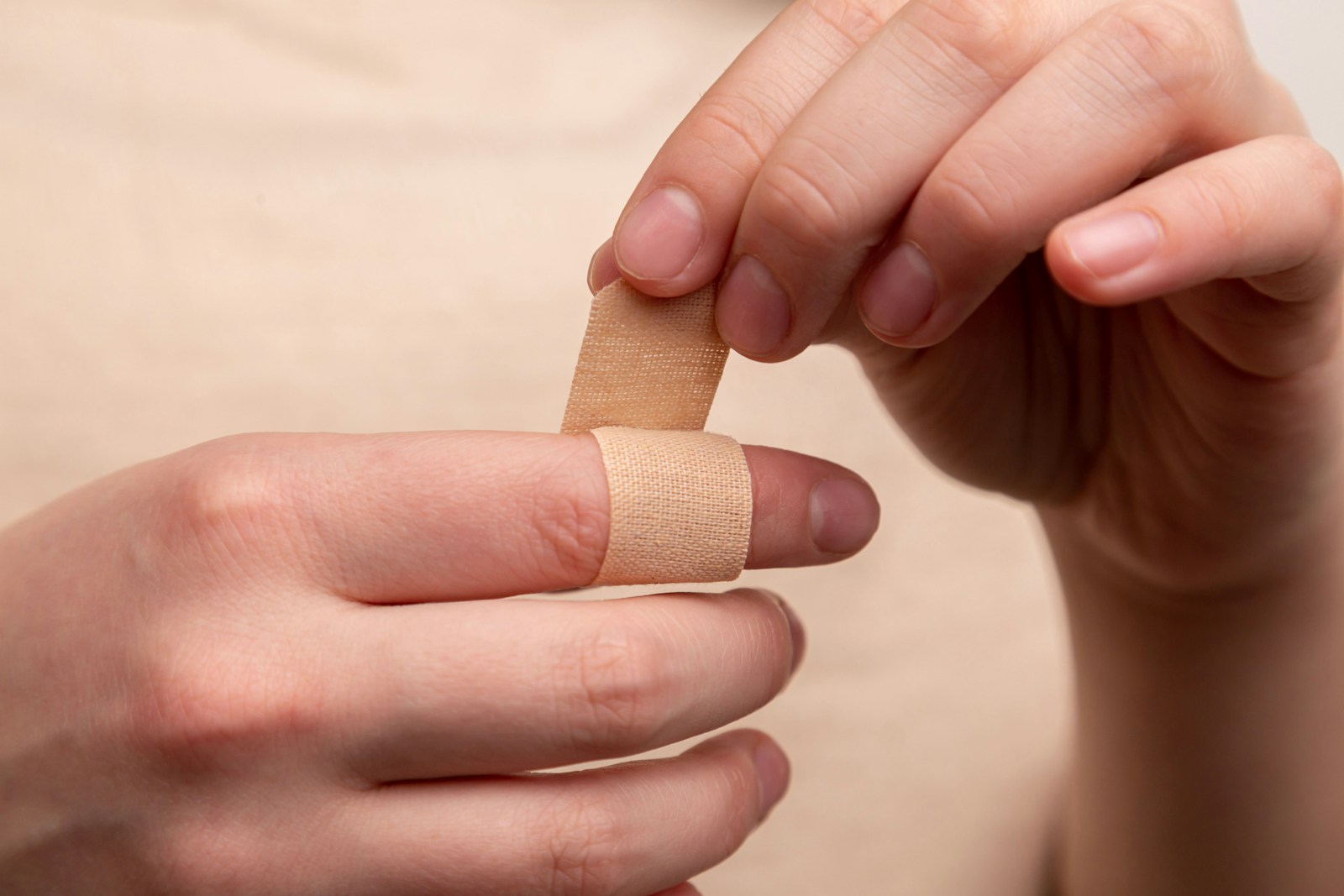 person with band aid on middle finger caused by an injury good thing you have small business liability insurance